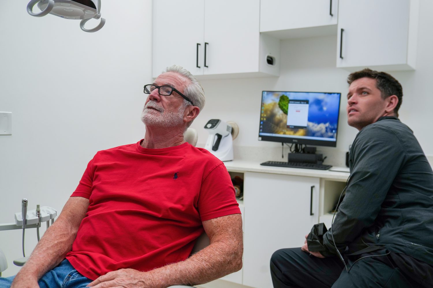 El Dr. Dillon revisando imágenes con un paciente junto al sillón en MSD Dental Studio, Coral Springs