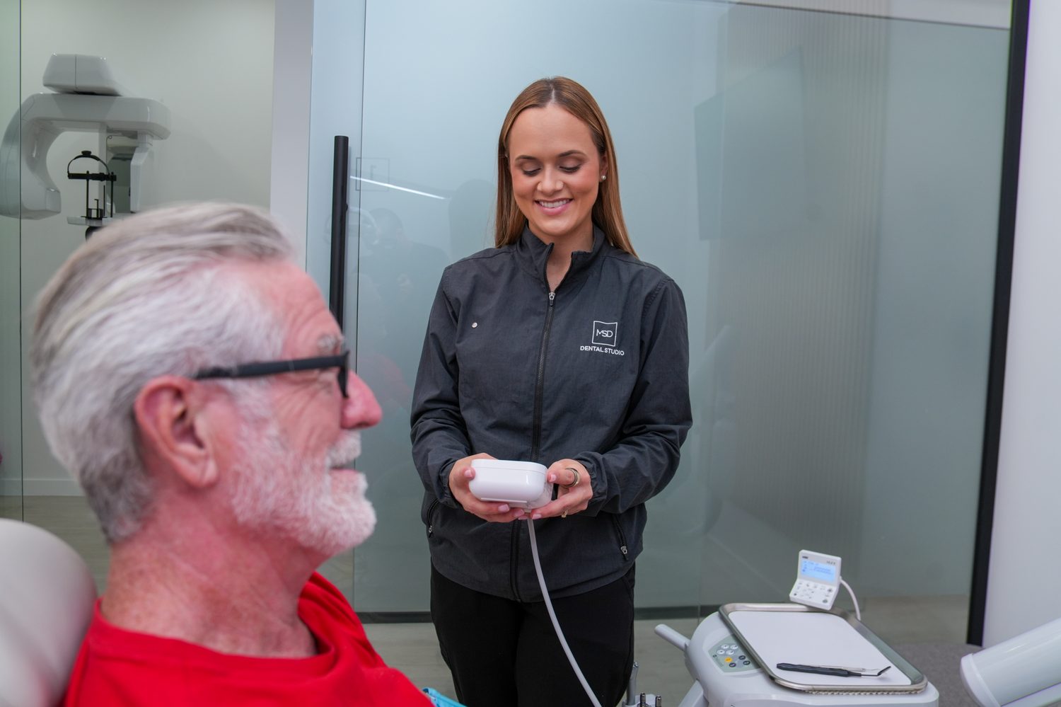 Un miembro del equipo mostrando a un paciente nuestra tecnología de escaneo digital en MSD Dental Studio, Coral Springs